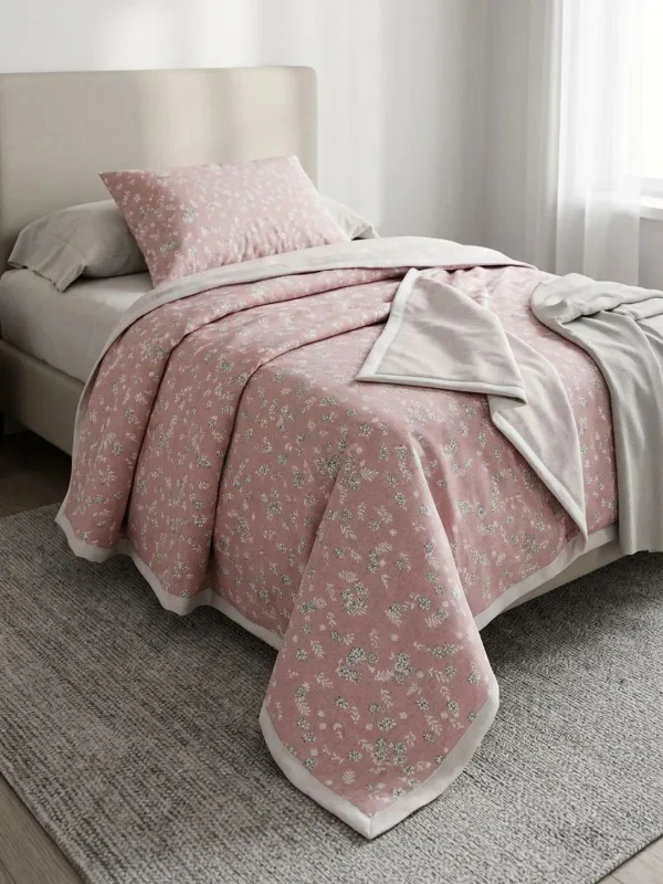 Dusty Rose Ditsy Floral 300 GSM cotton single bed quilt in dusty rose, styled on a single bed