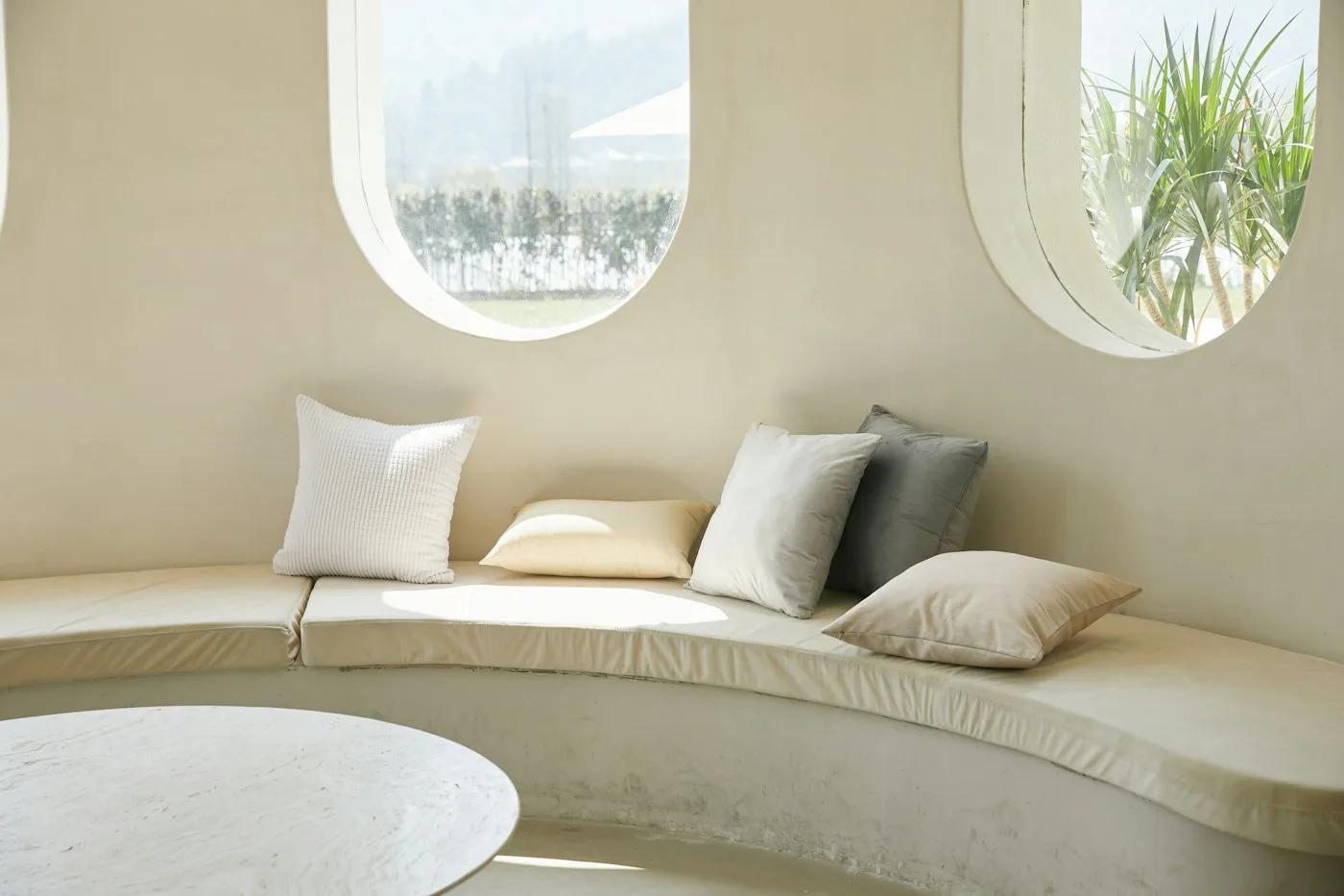 Curved window seat styled with soft neutral cushions