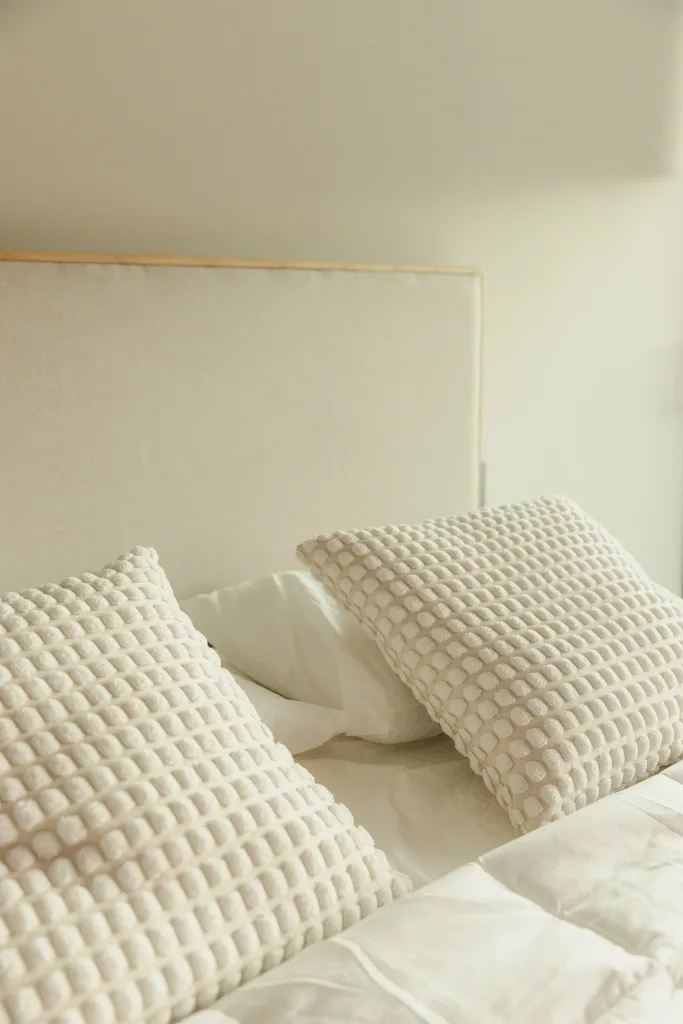 Cream textured pillows on a linen-covered bed